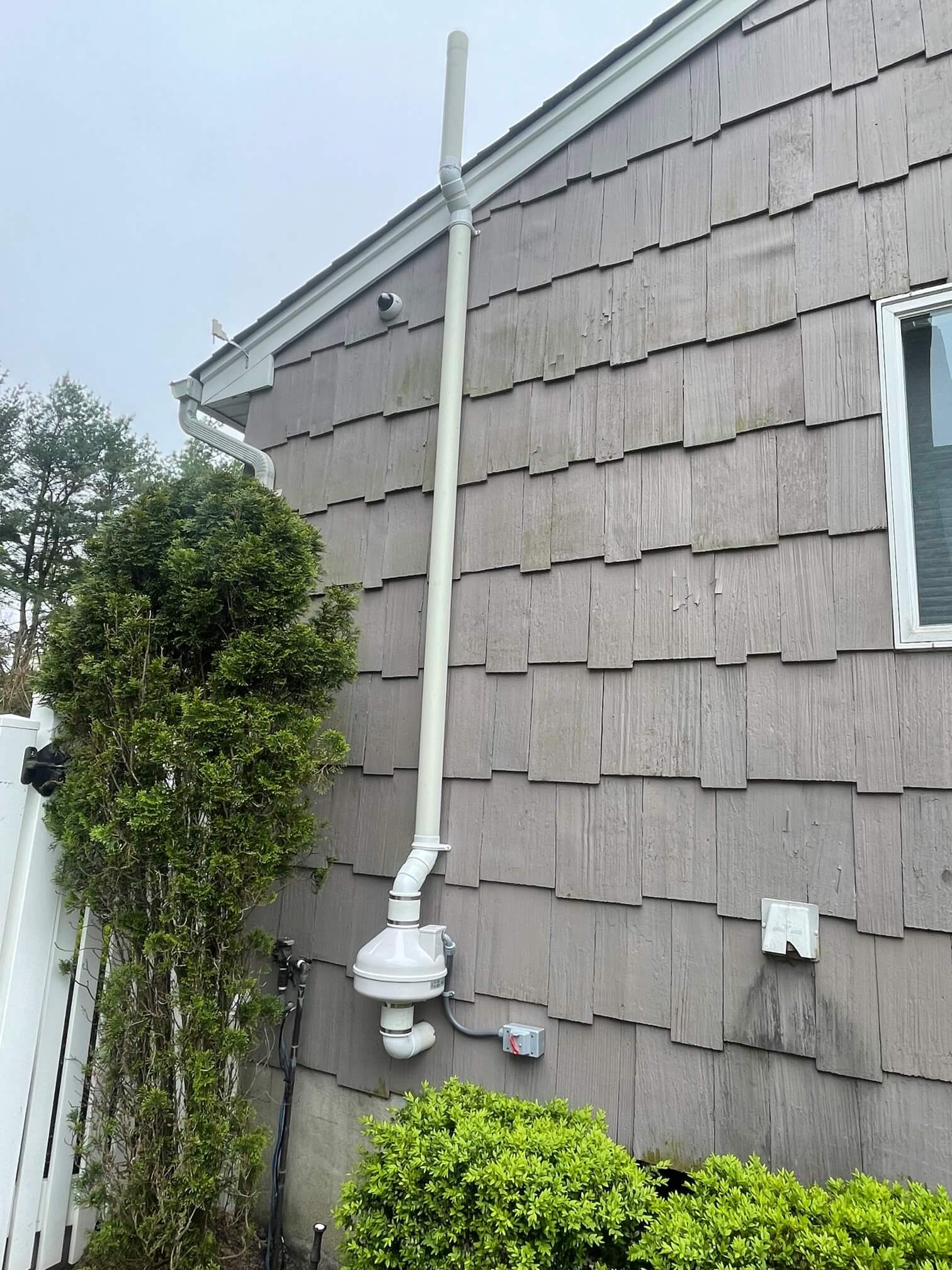 Radon mitigation system vent pipe on a house exterior