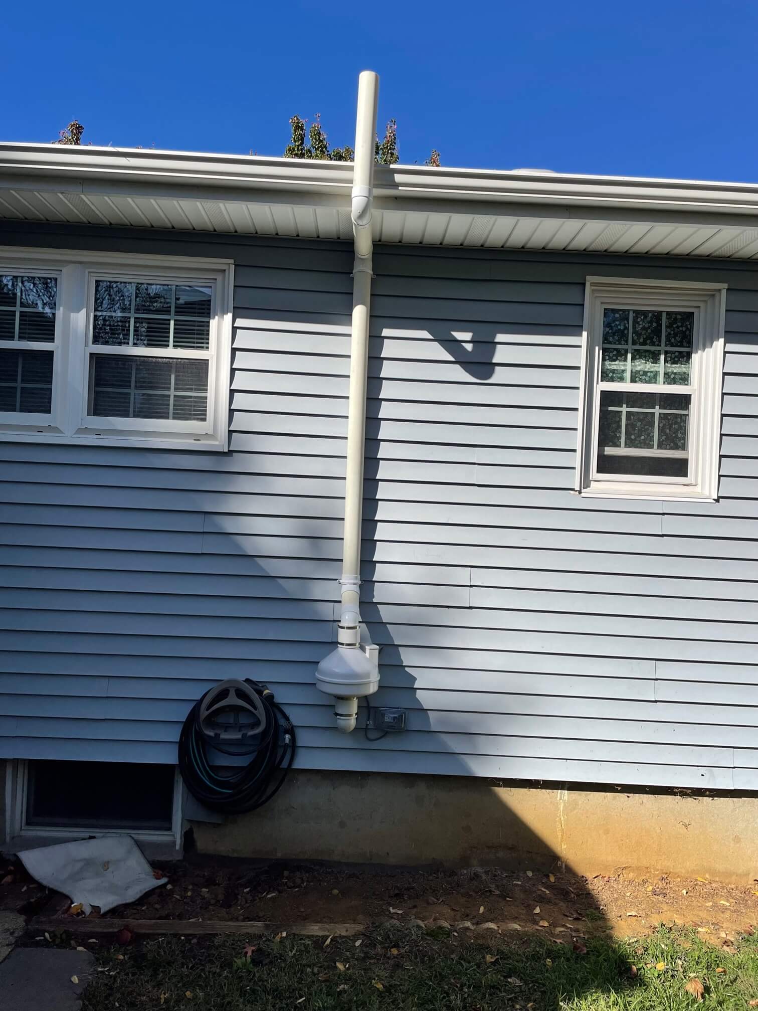 Exterior shot of a radon mitigation system with exhaust pipe