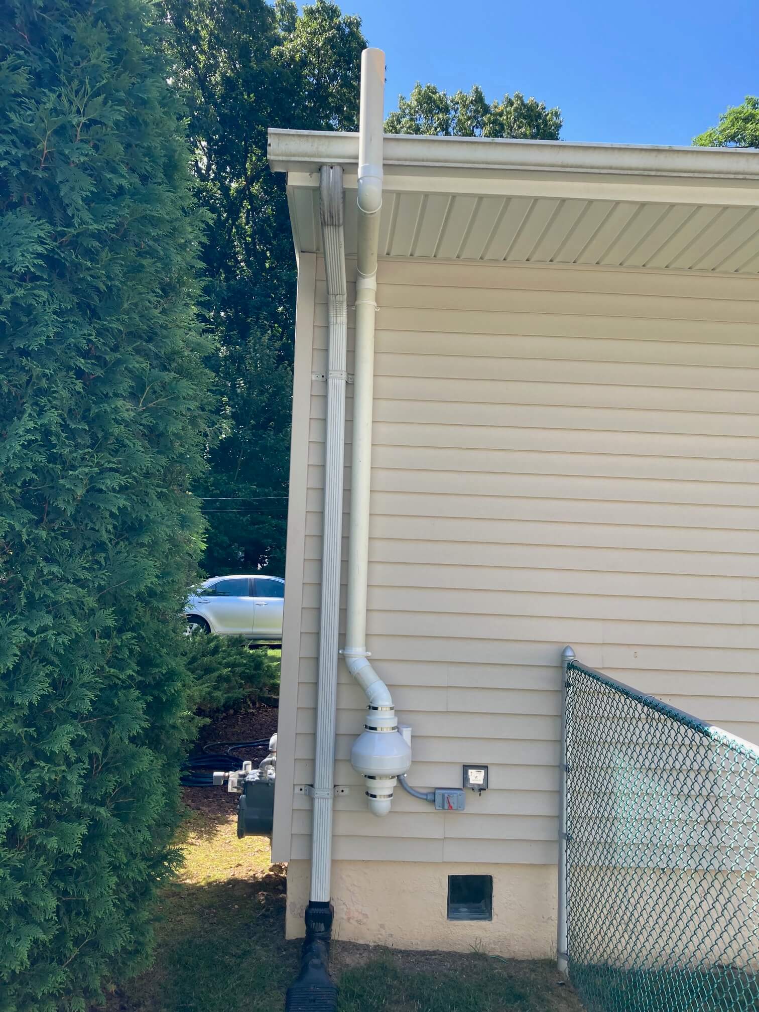 Exterior shot of a radon mitigation system with exhaust pipe